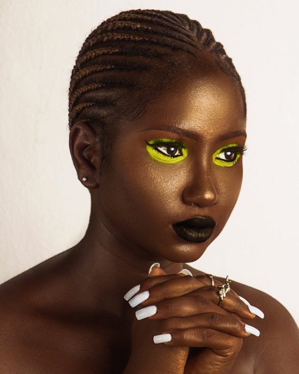beautiful young black woman with golden shimmering makeup looking away