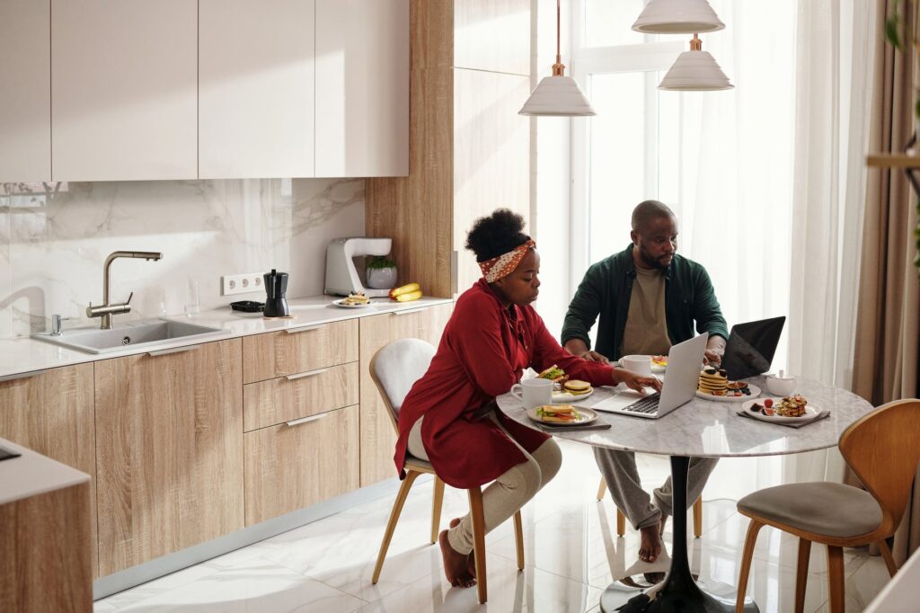 couple using their laptops while having breakfast